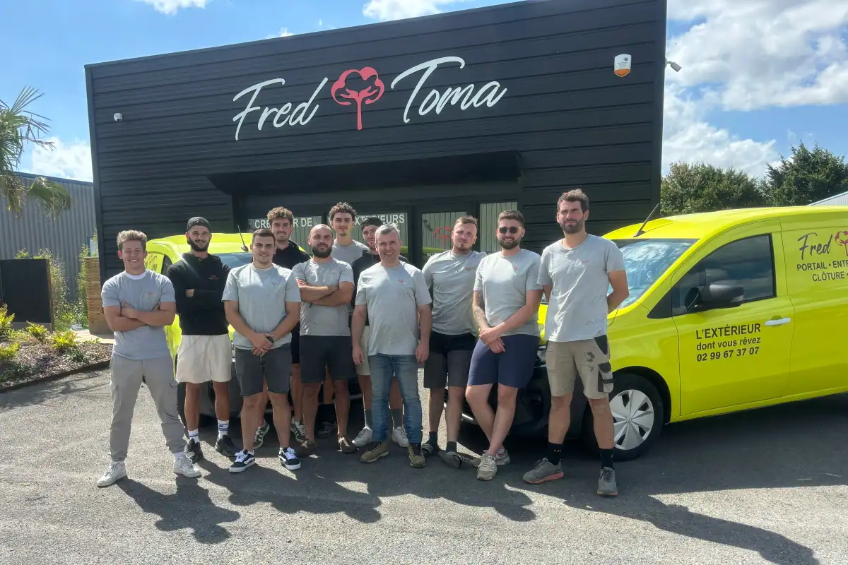 Photo de l'équipe Fred Toma Rennes : nos 10 techniciens qualifiés devant un véhicule logoté.