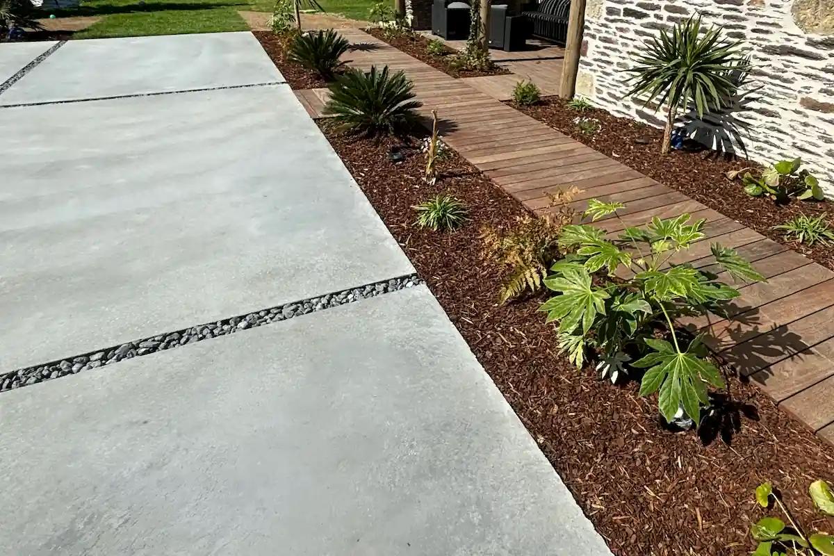 Cour en béton moderne et chemin en bois avec paillage, aménagement de cour par Fred Toma Rennes.