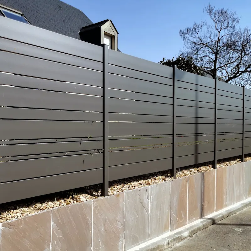 Installation de panneaux de clôture alu occultants sur un muret à Rennes.