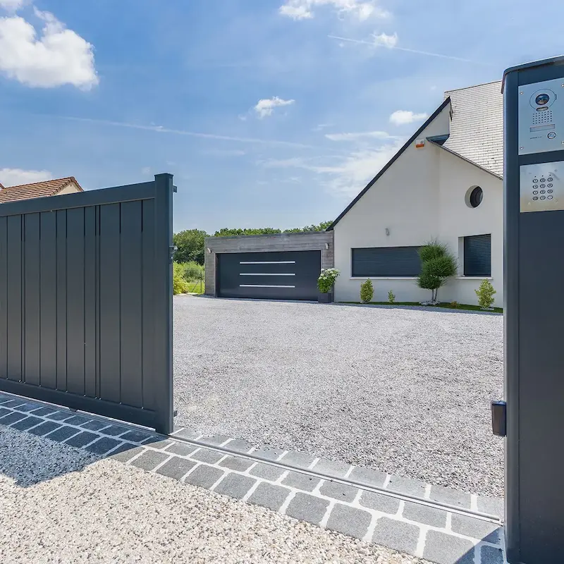 Détail d'un visiophone et d'une cellule de détection intégrés sur un pilier de portail à Rennes.